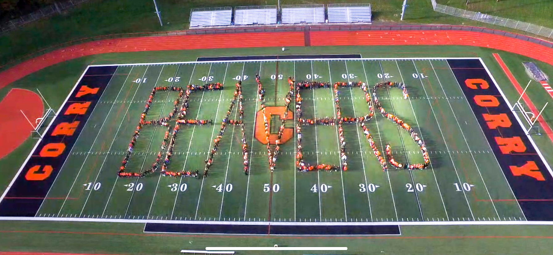 drone aerial view of students spelling out Beavers on football field