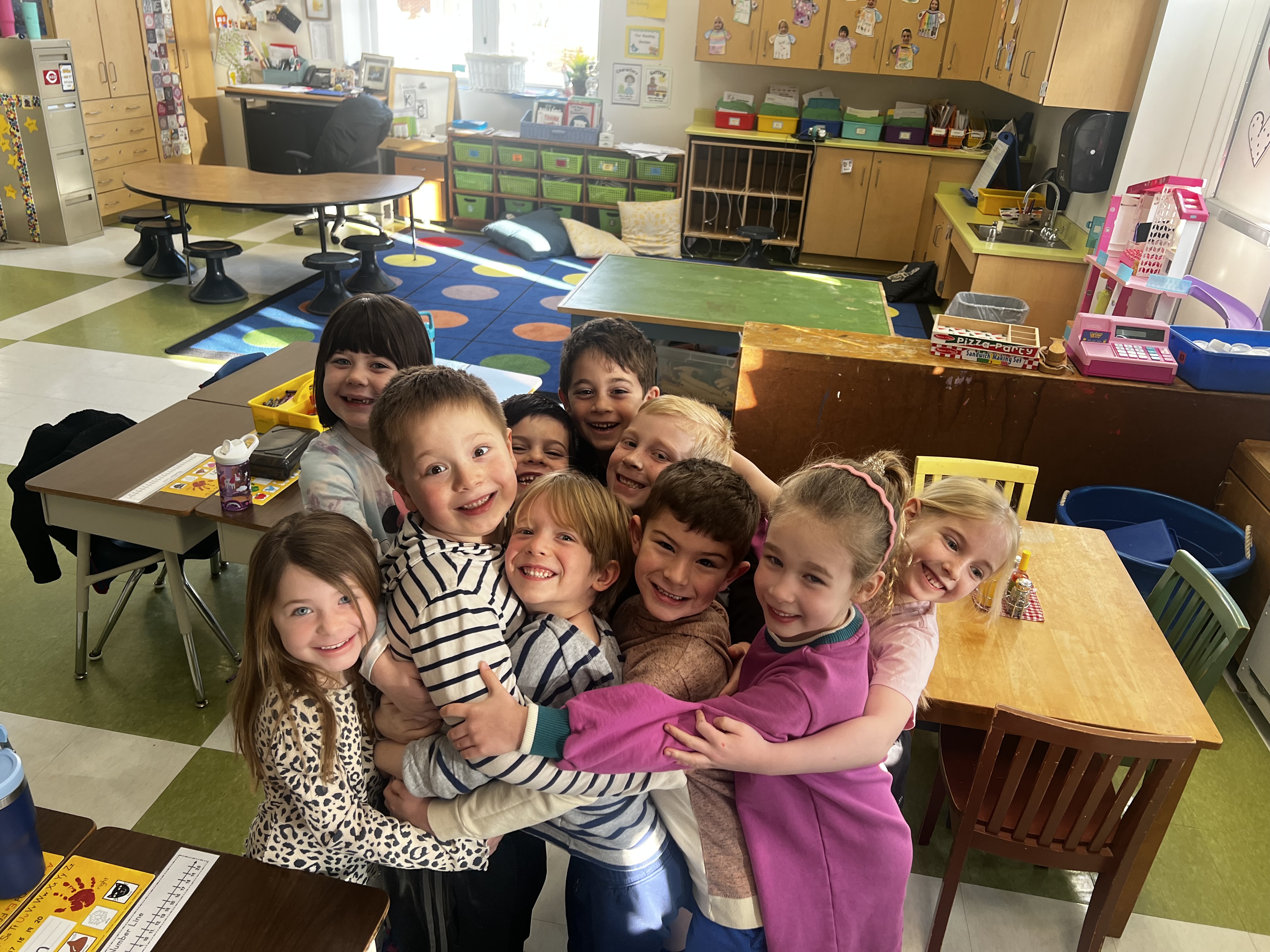 kindergarten kids smiling in a group hug