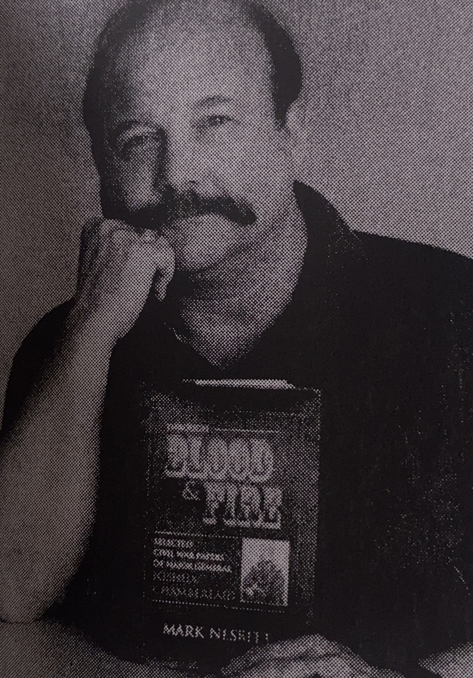 man posing holding a book