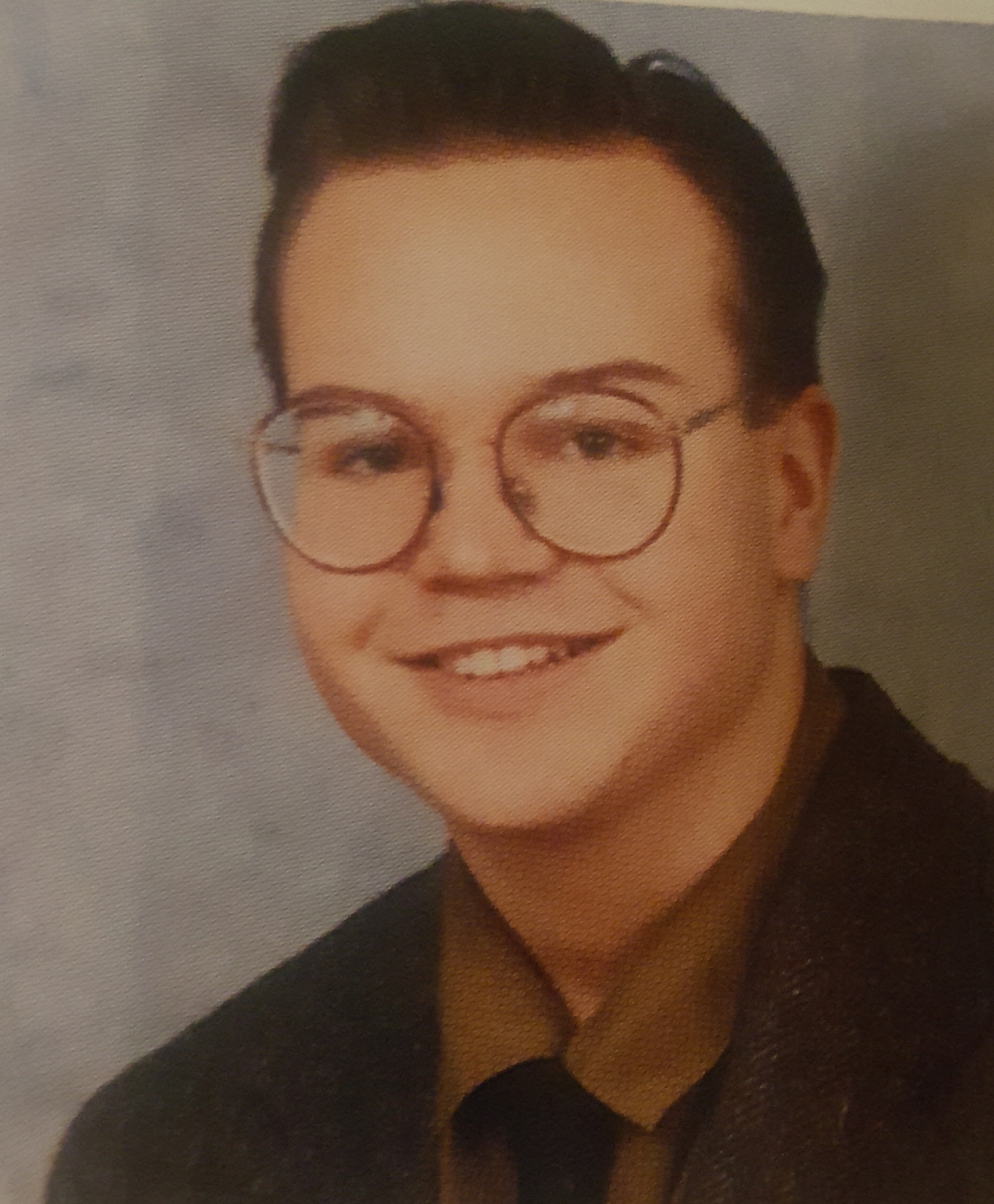 young man smiling wearing glasses