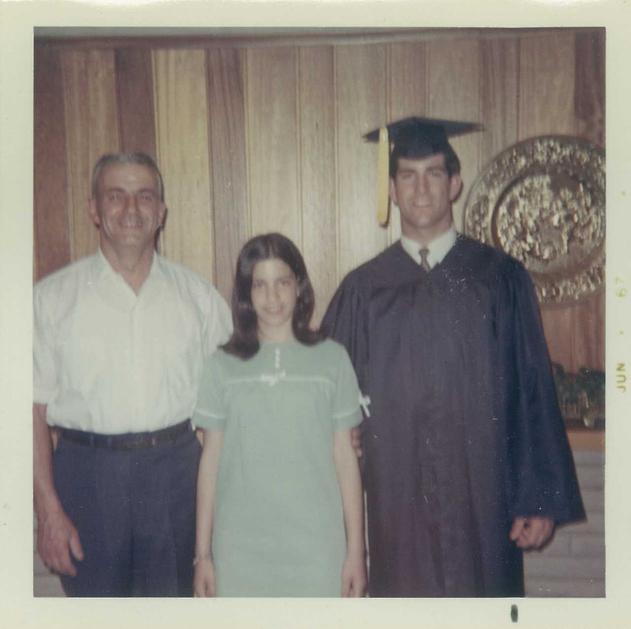 family smiling with graduate in graduation cap and gown