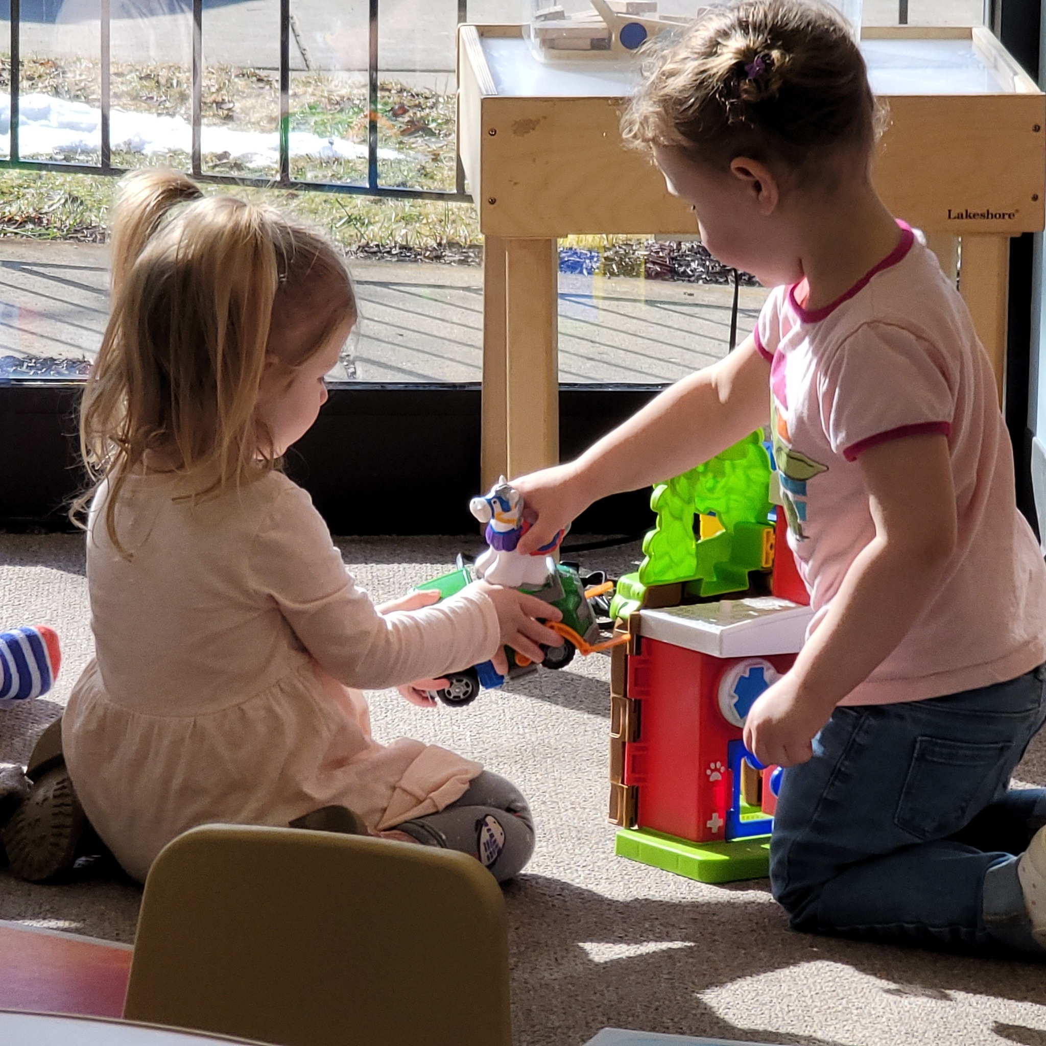two preschoolers playing with toys