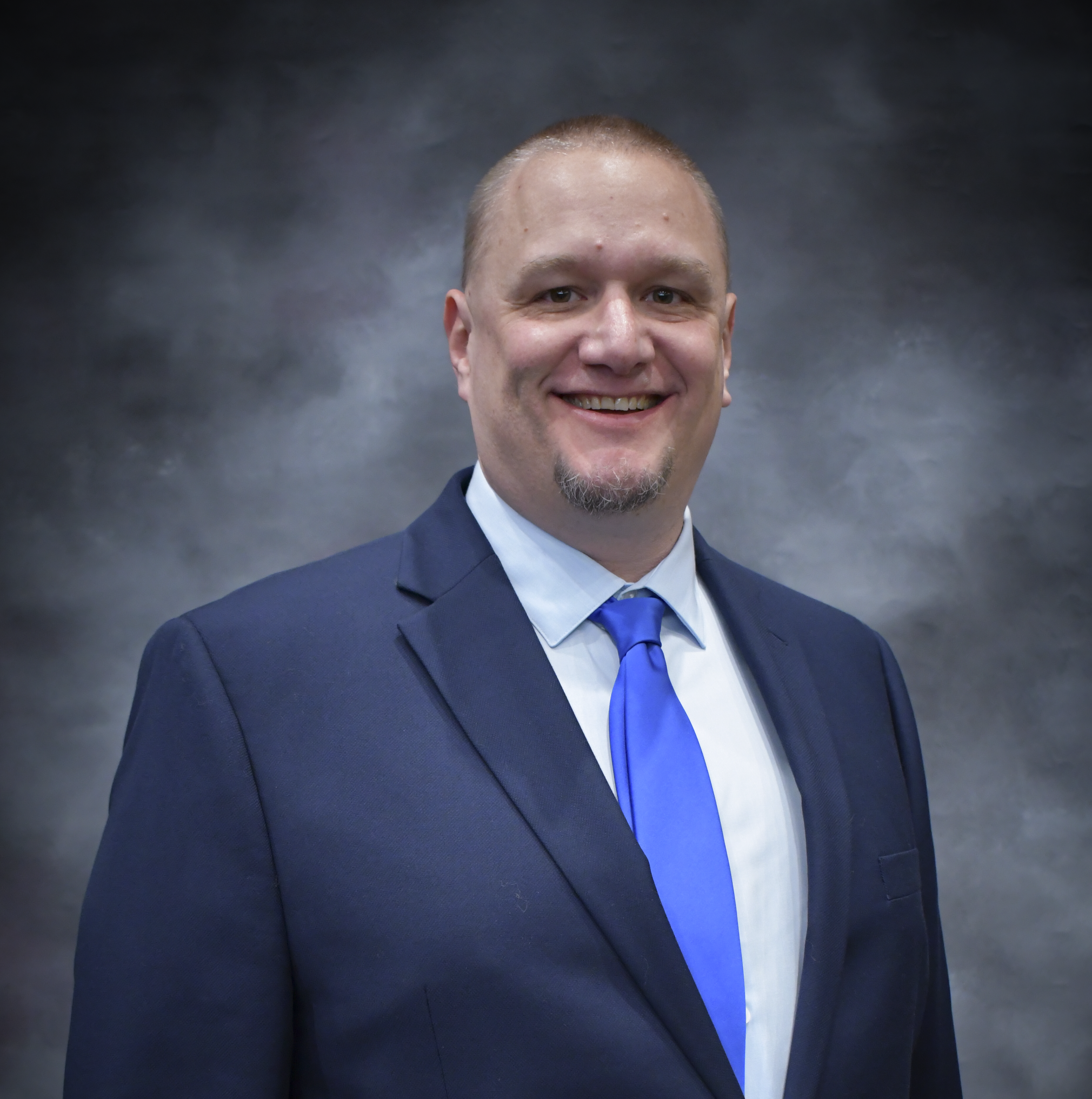 Man in a navy suit and blue tie