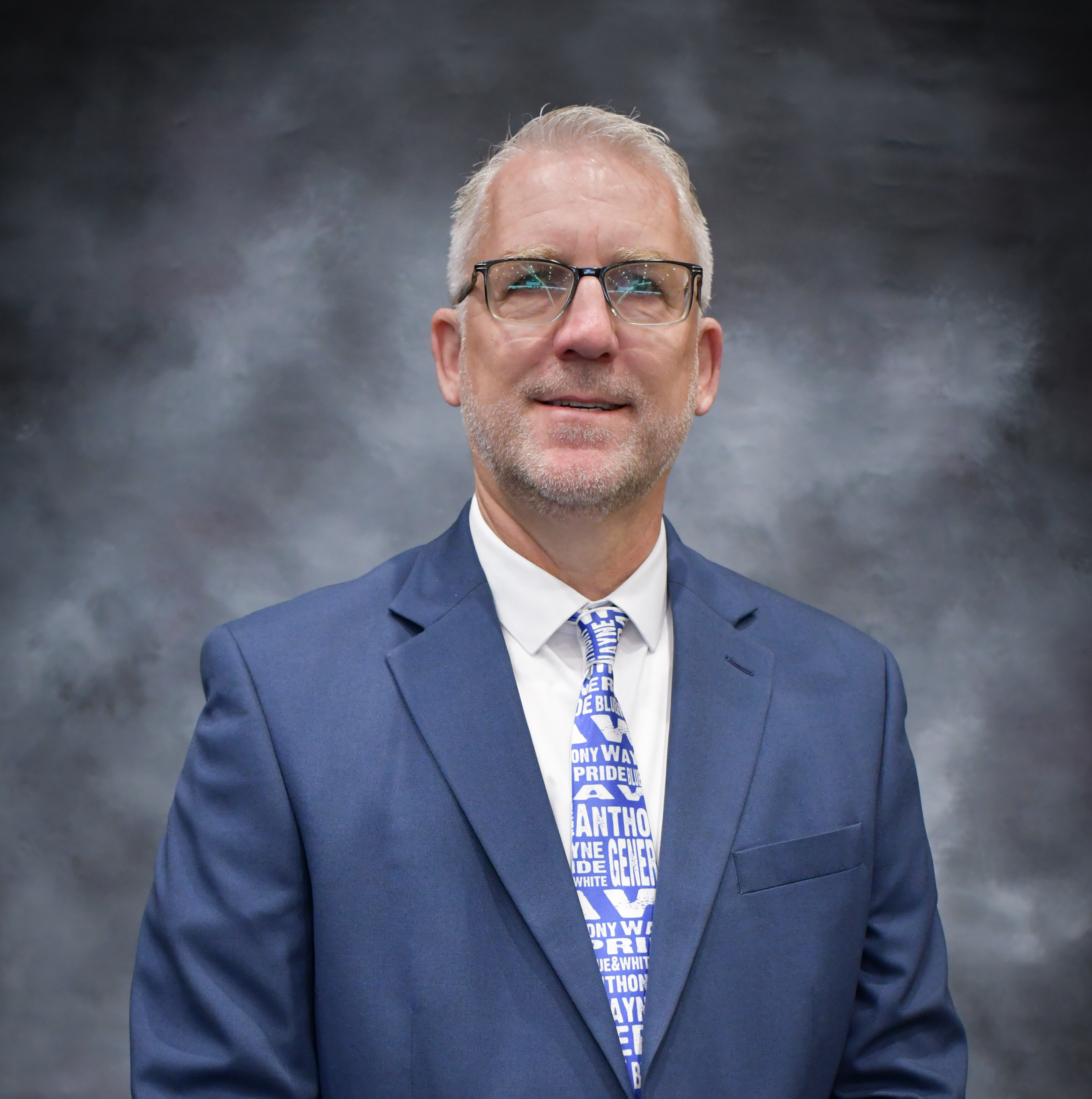 Man in a suit with AW necktie and glasses