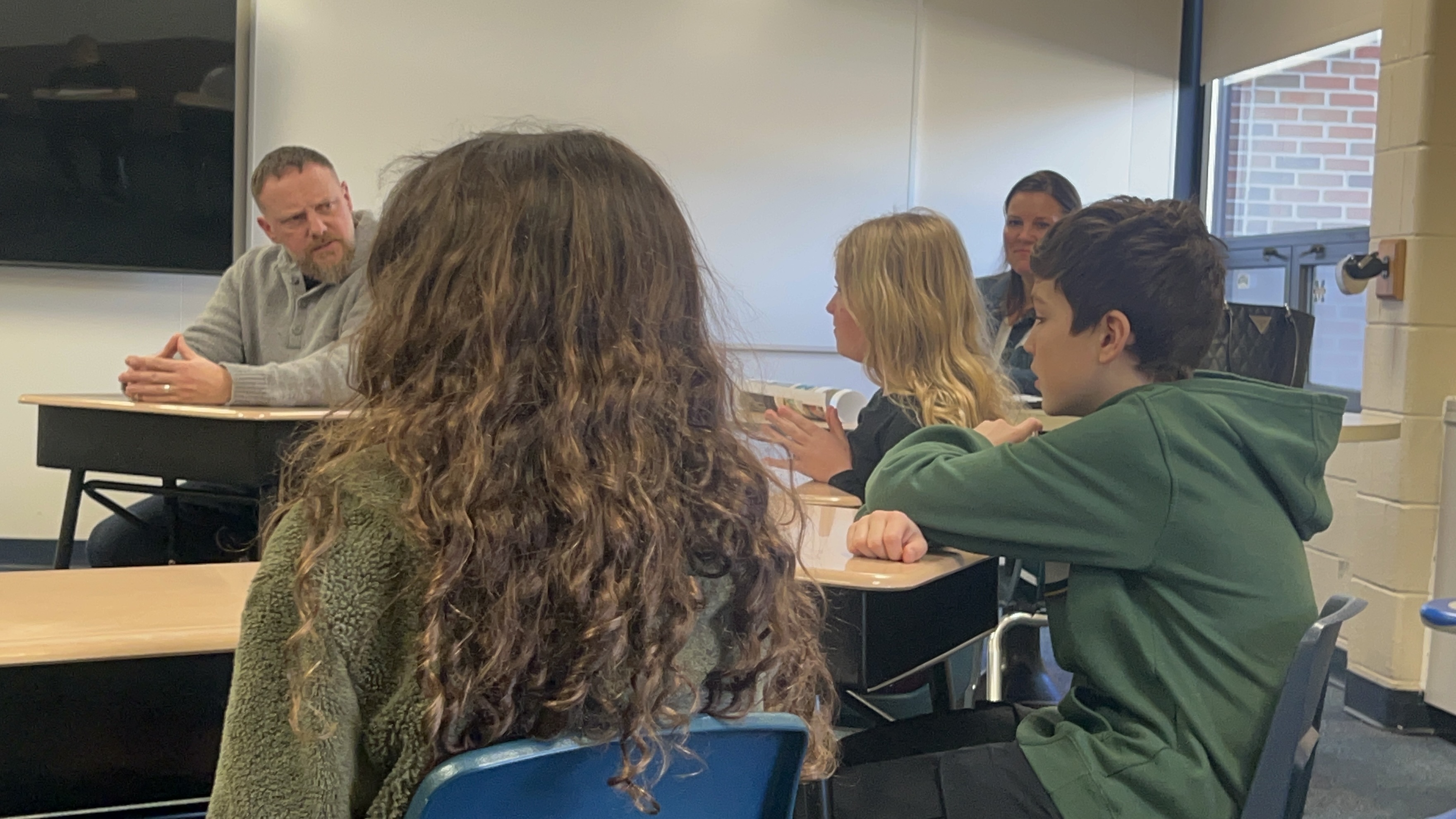 a group of students talk to a man