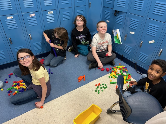 Mrs. Myers' students pictured playing on the floor with building materials.