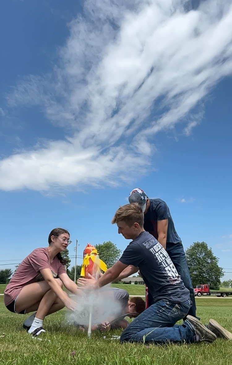 A group of 3 students releasing their rocket.