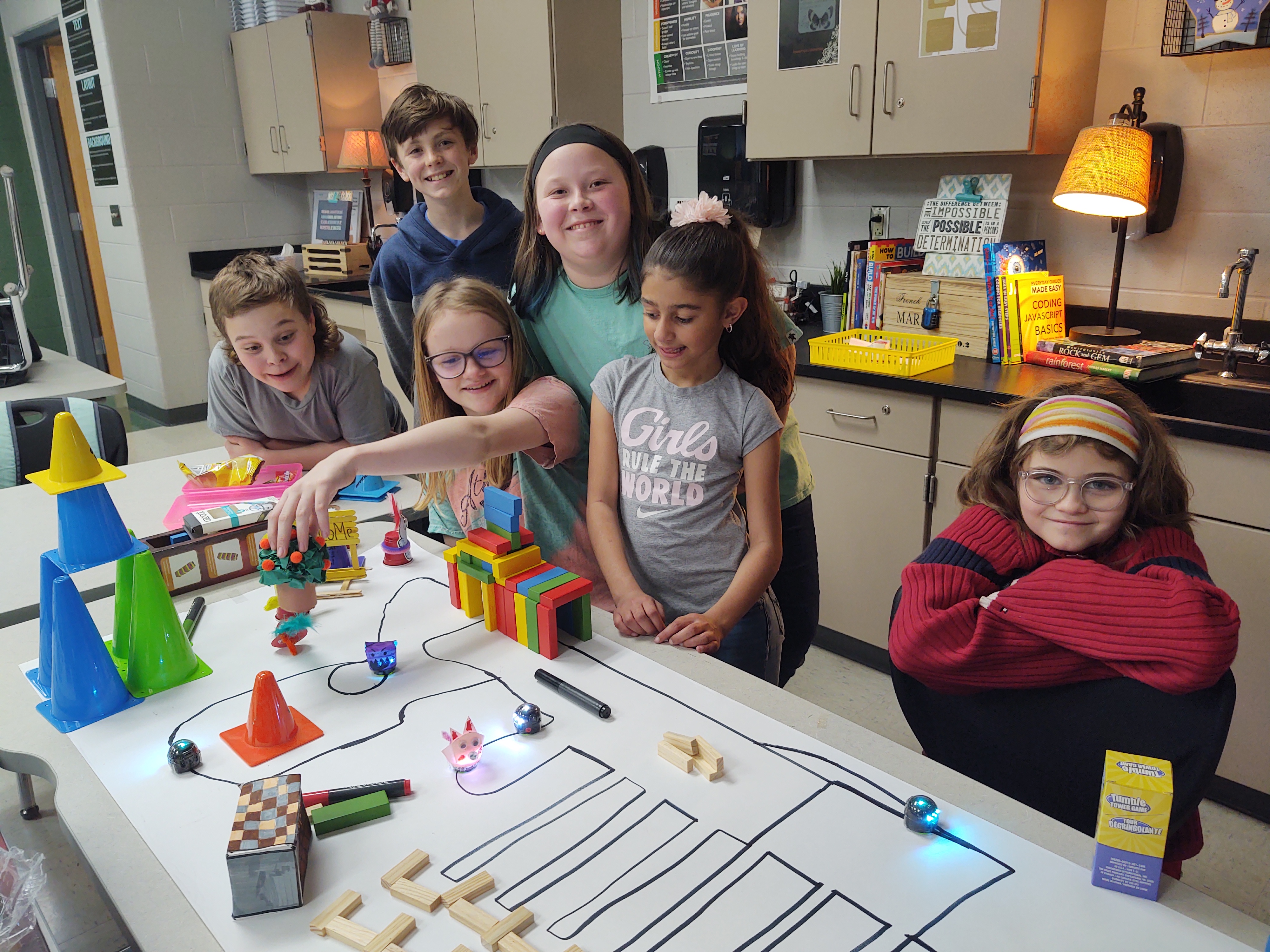 Six robotics club members pictured with their ozobots and track.