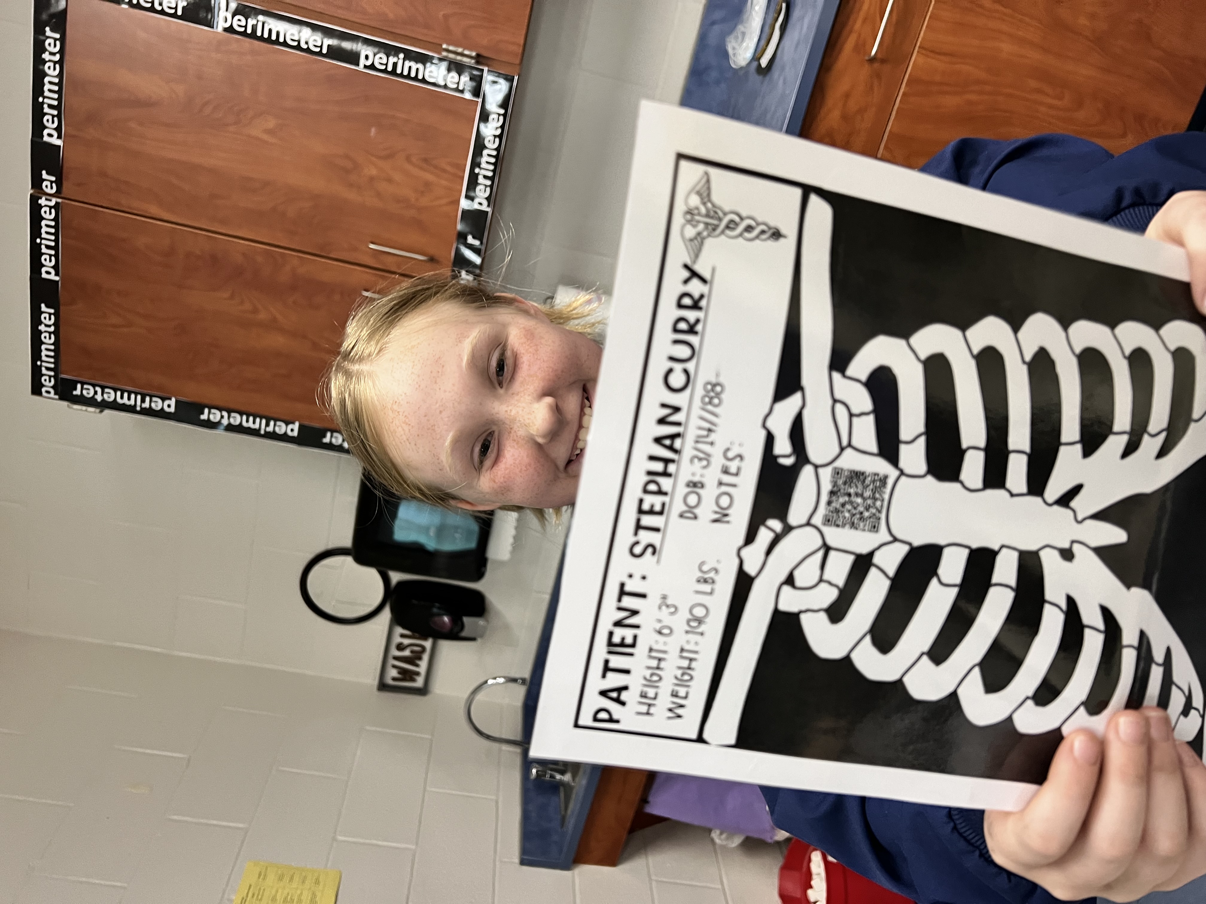 A student shows her mock x-ray of Stephan Curry