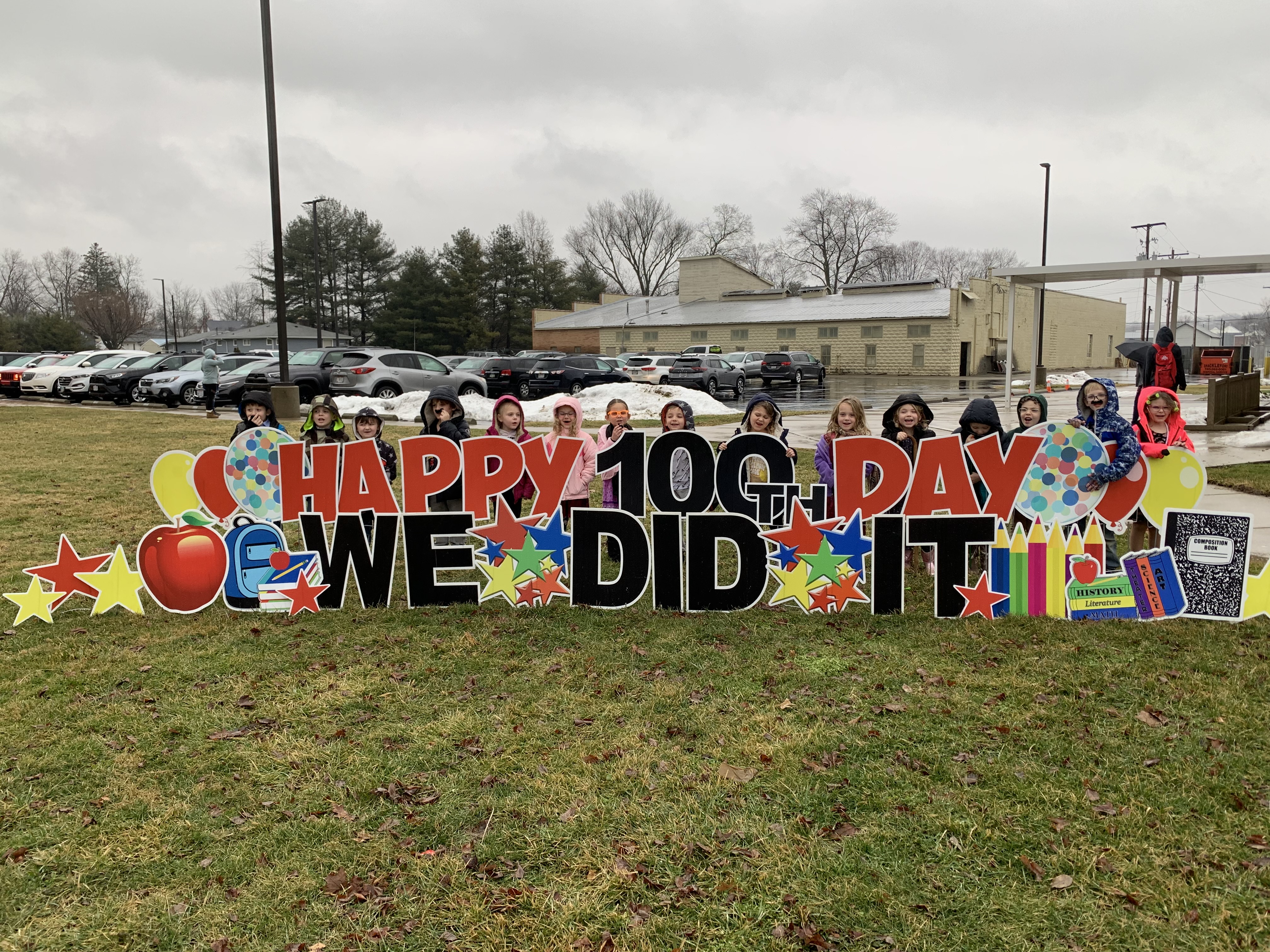Photo of students by 100th Day yard sign