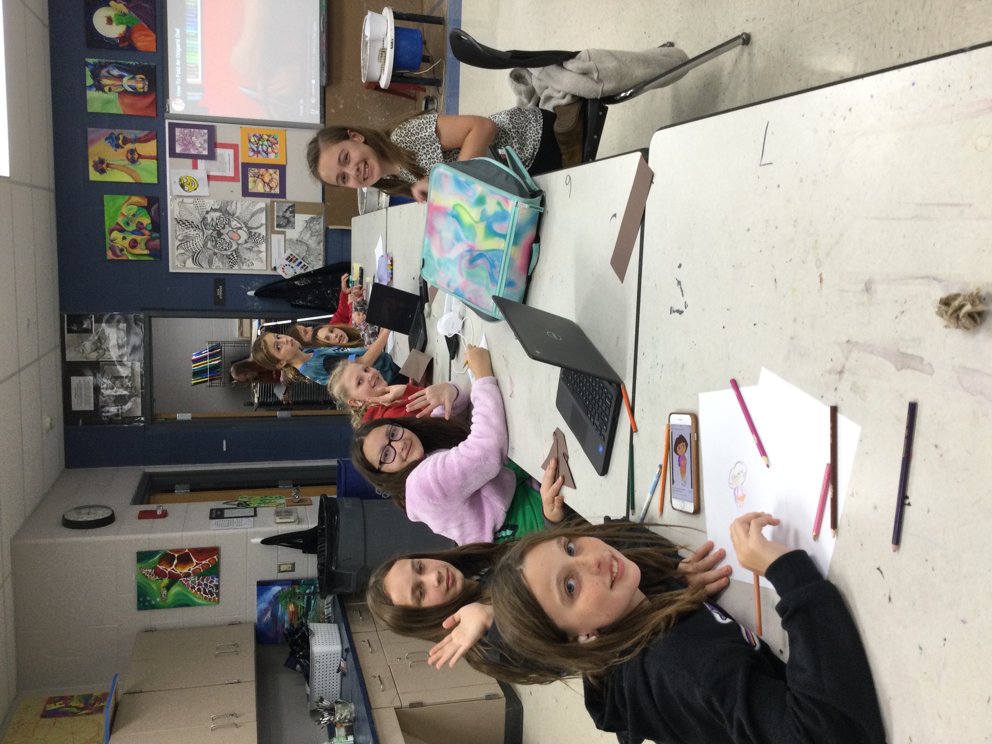 Art students sitting at a table during art club.