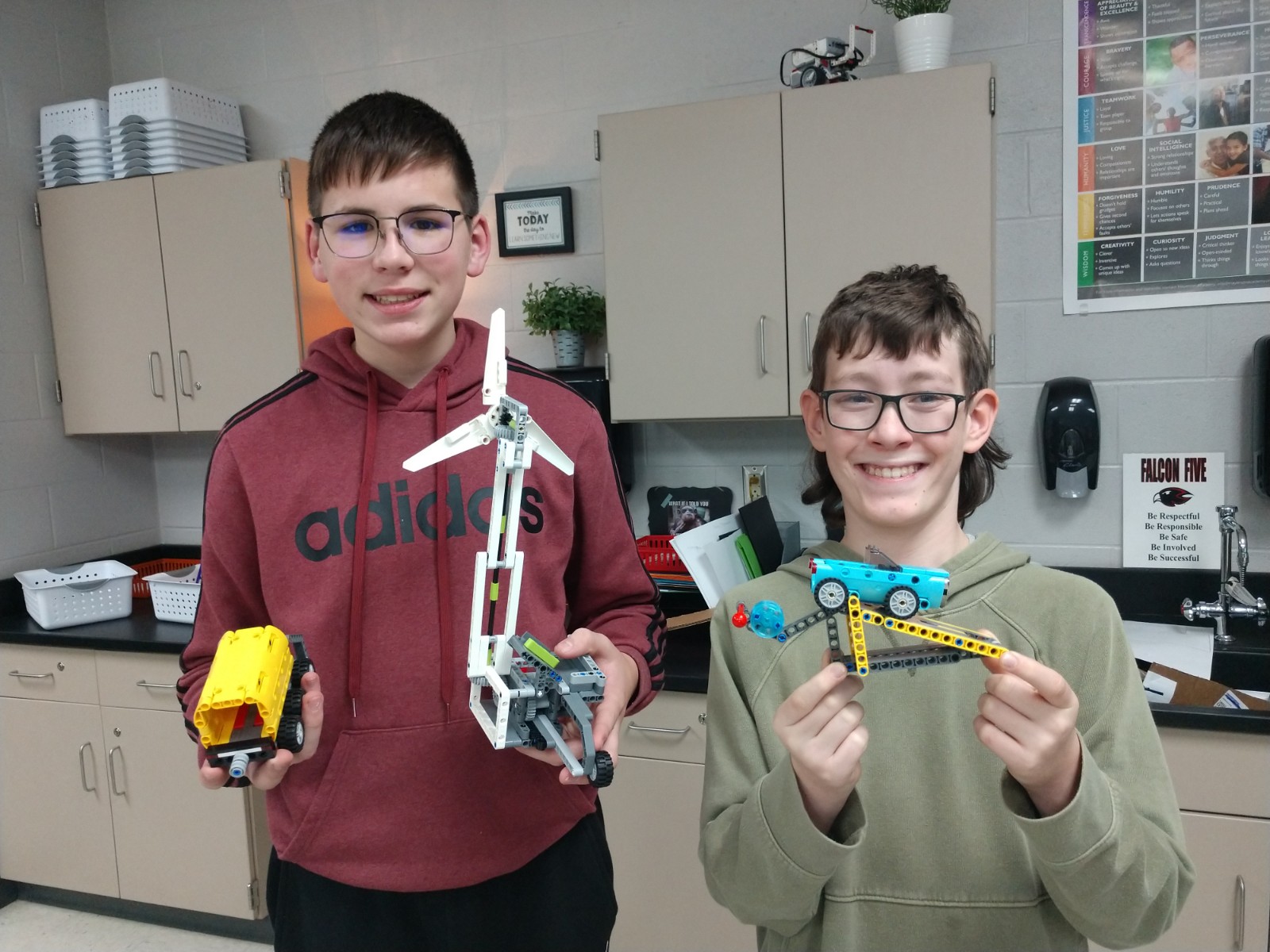 Two students show off their robotic club work