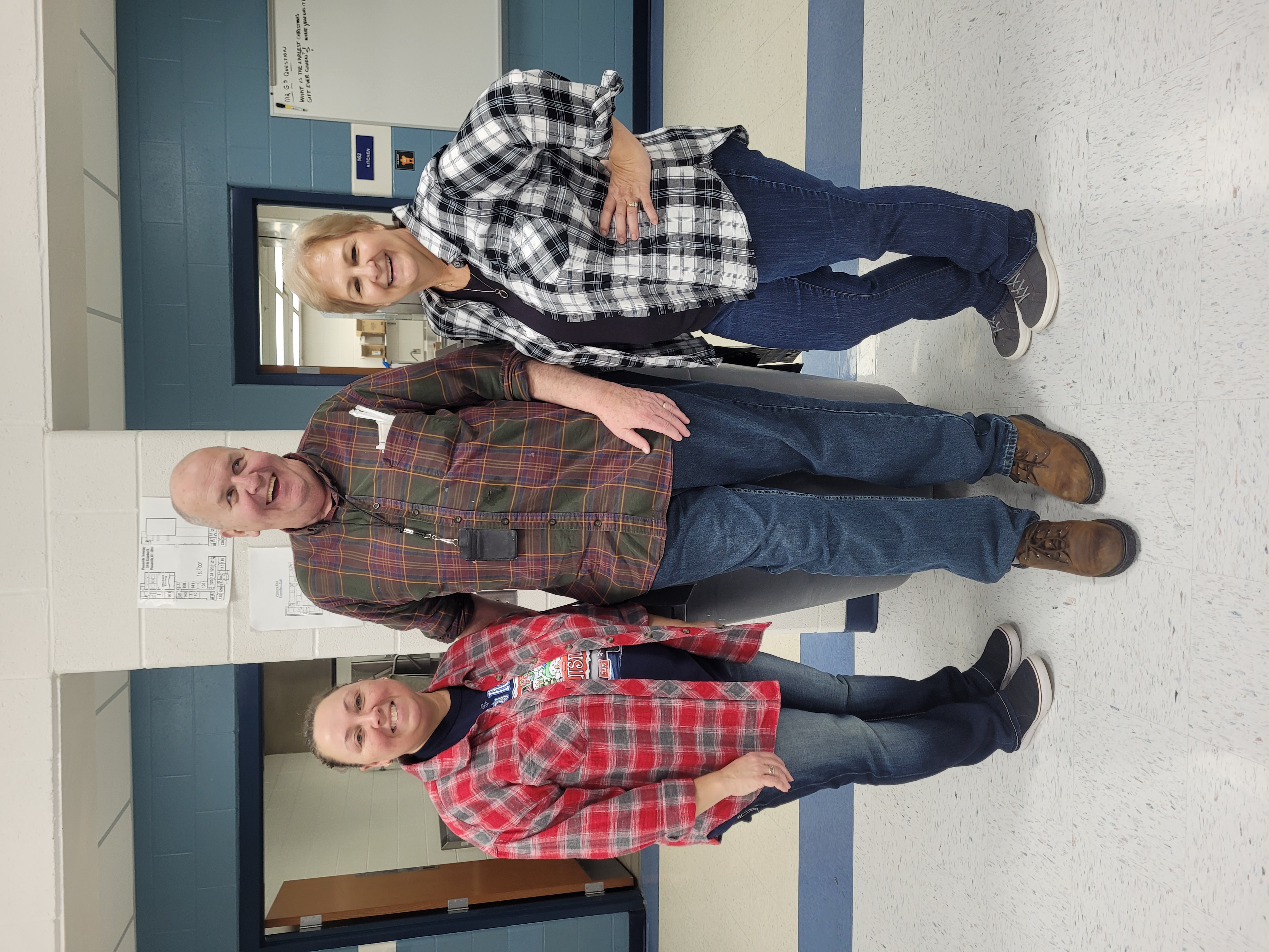 Teachers pose with Dan Gallagher on plaid day