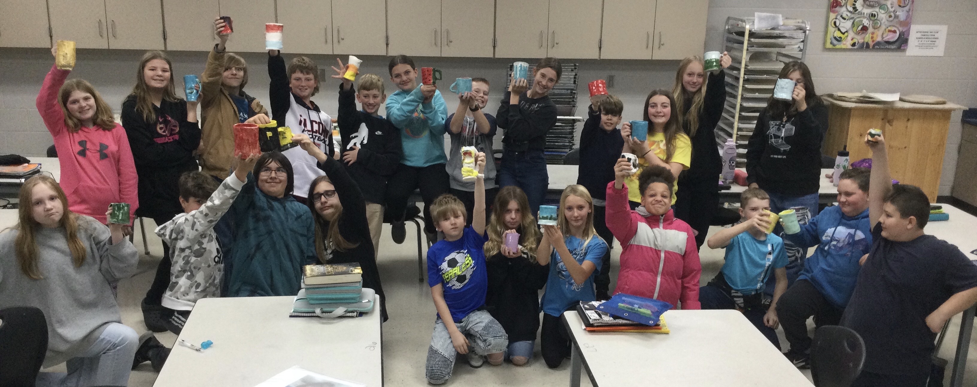 Classroom photo of students holding their mugs