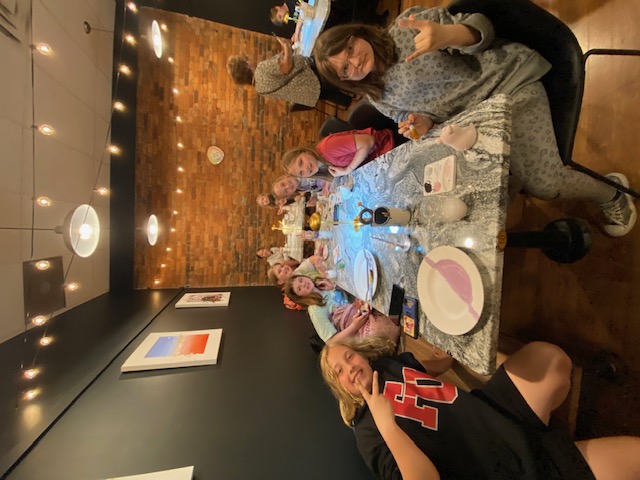 A full table of 5th grade students painting their pottery at Art and Clay