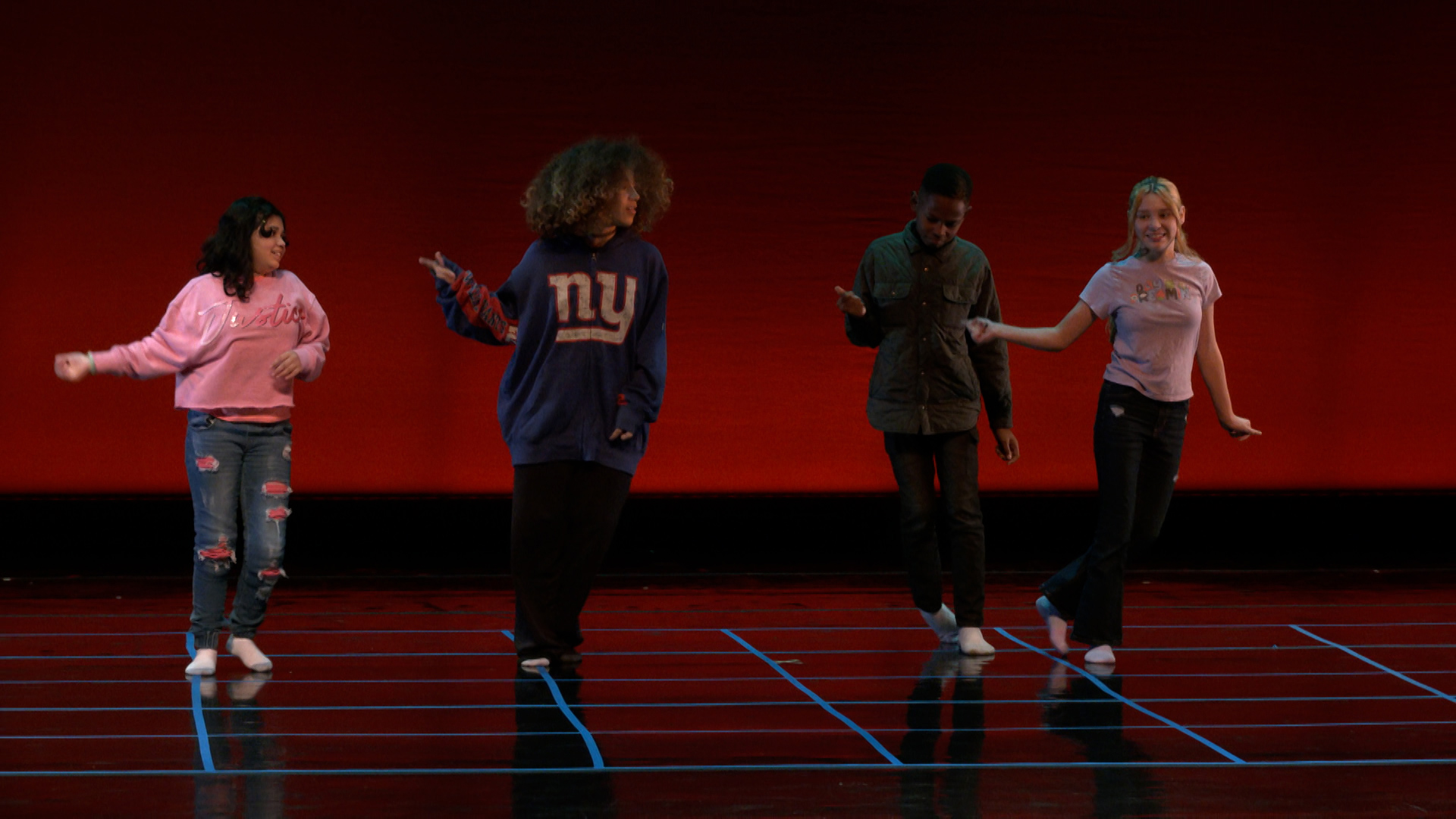 four kids dancing on a stage. 