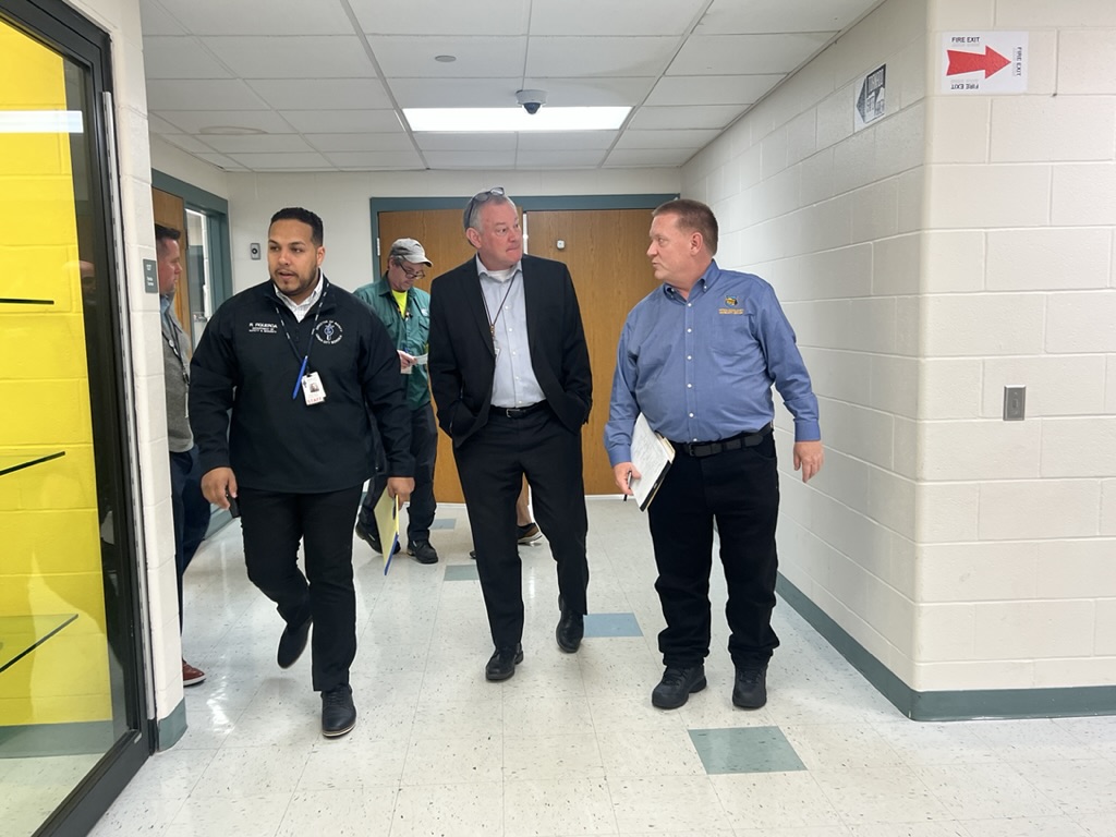 Three men walking down the hallway in a school